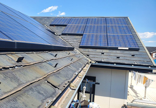 劣化したスレート屋根に設置された太陽光パネルの写真